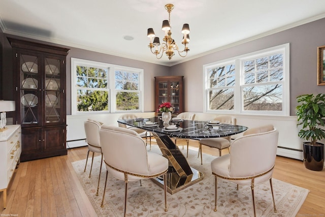 dining room featuring a chandelier, light wood-style floors, baseboard heating, and crown molding