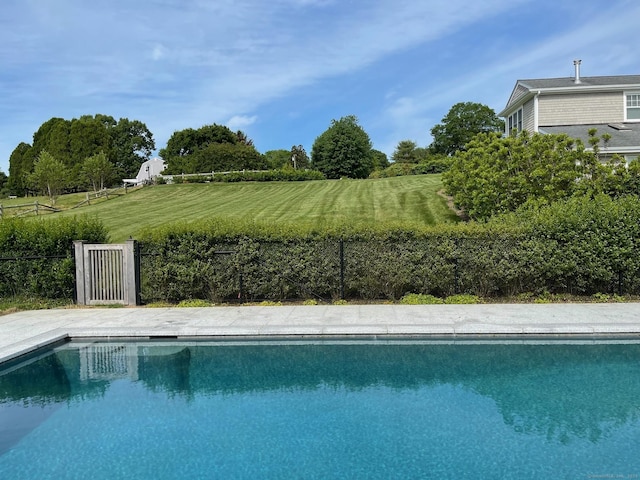 outdoor pool featuring a yard and fence