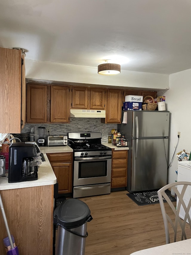 285 Dayton Rd, Bridgeport, CT 06606 - kitchen with tasteful backsplash, light countertops, under cabinet range hood, stainless steel appliances, and light wood-style flooring
