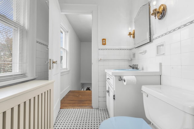 90 Culloden Rd, Stamford, CT 06902 - half bath featuring toilet, tile patterned floors, tile walls, wainscoting, and vanity