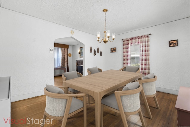 90 Culloden Rd, Stamford, CT 06902 - dining space with an inviting chandelier, wood finished floors, a textured ceiling, baseboards, and arched walkways