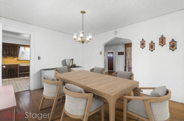 90 Culloden Rd, Stamford, CT 06902 - dining space with a textured ceiling, dark wood-style flooring, baseboards, arched walkways, and a chandelier