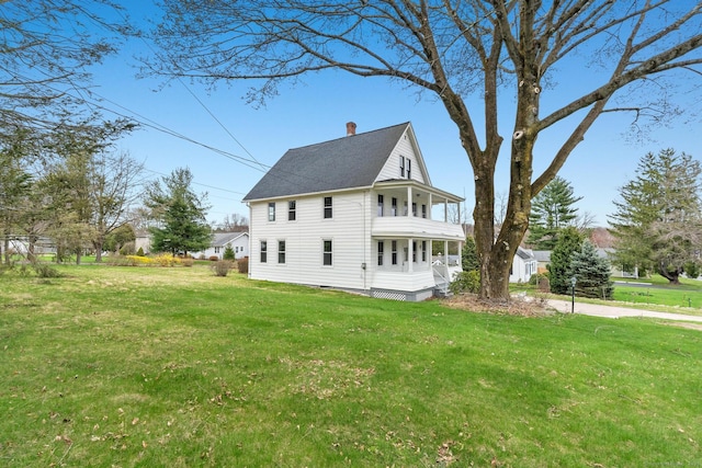 view of side of home with roof with shingles, a balcony, a chimney, a lawn, and covered porch
