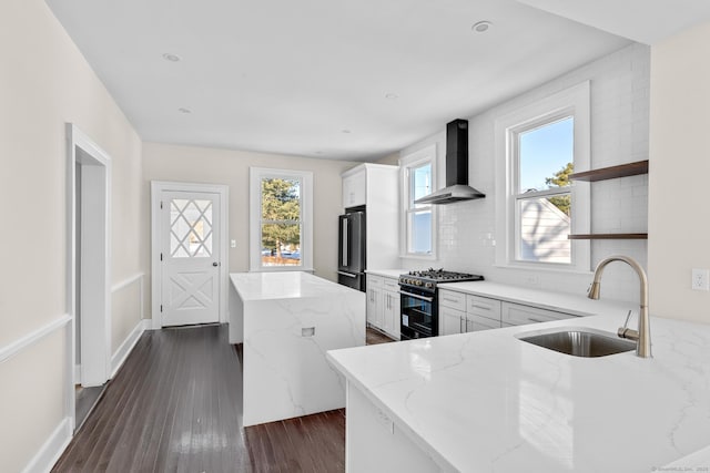 189 Derby Ave, Orange, CT 06477 - kitchen with range with gas cooktop, wall chimney exhaust hood, open shelves, light stone countertops, and high end black fridge