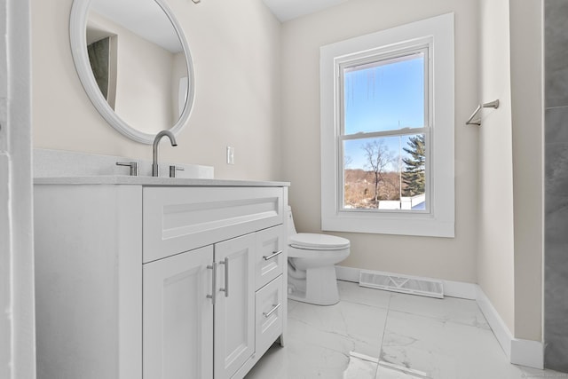 bathroom featuring a wealth of natural light, vanity, visible vents, marble finish floor, and baseboards