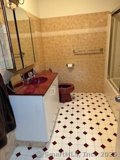 278 Wall St, Waterbury, CT 06704 - full bathroom featuring tile walls, toilet, vanity, and a wainscoted wall
