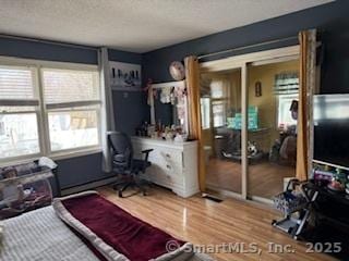 278 Wall St, Waterbury, CT 06704 - bedroom with a baseboard heating unit, wood finished floors, and a textured ceiling