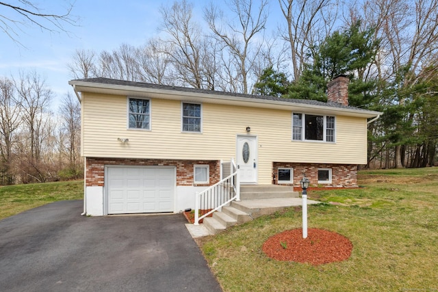 split foyer home with driveway, a chimney, a front yard, and a garage