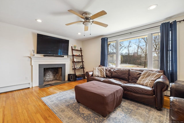 living area with ceiling fan, a brick fireplace, hardwood / wood-style floors, and recessed lighting