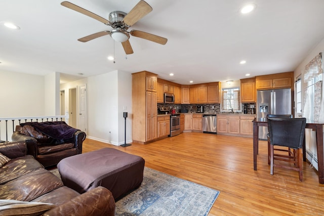 living room with a healthy amount of sunlight, light wood finished floors, and a ceiling fan