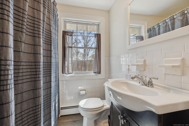 full bath with wood finished floors, toilet, vanity, a baseboard heating unit, and tile walls