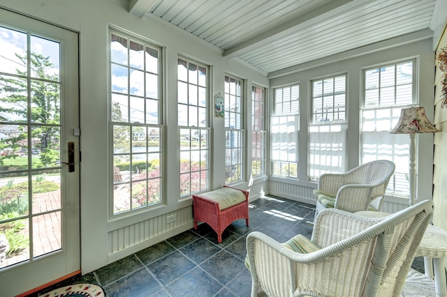 sunroom featuring beam ceiling and a wealth of natural light