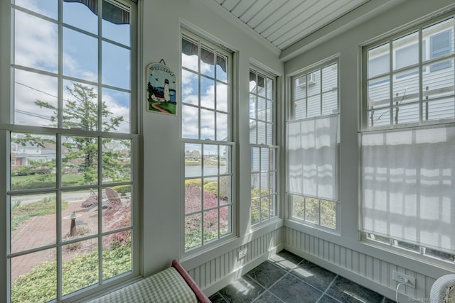 unfurnished sunroom with a water view and a healthy amount of sunlight