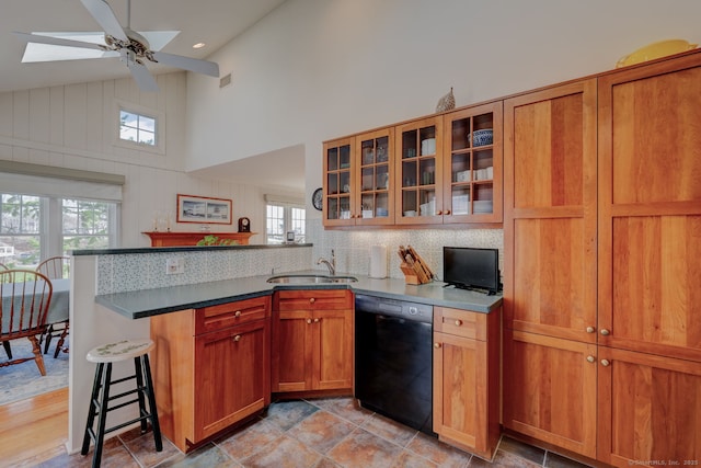 kitchen featuring a sink, a peninsula, high vaulted ceiling, a ceiling fan, and dishwasher