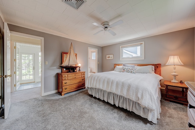 carpeted bedroom with visible vents, a ceiling fan, multiple windows, and ornamental molding