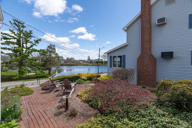 view of yard featuring a water view and a patio area