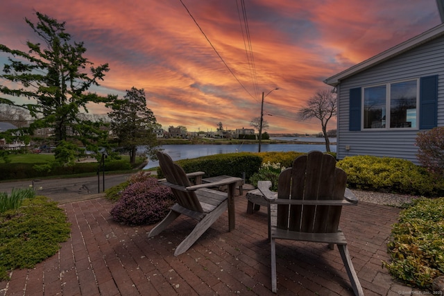 wooden deck with a water view and a patio area