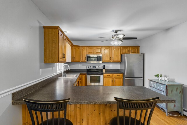 5 Ridge Ln, Shelton, CT 06484 - kitchen featuring a peninsula, dark countertops, ceiling fan, a sink, and stainless steel appliances