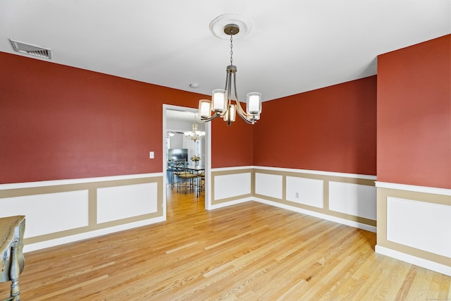 5 Ridge Ln, Shelton, CT 06484 - spare room featuring visible vents, wainscoting, a decorative wall, wood finished floors, and a chandelier