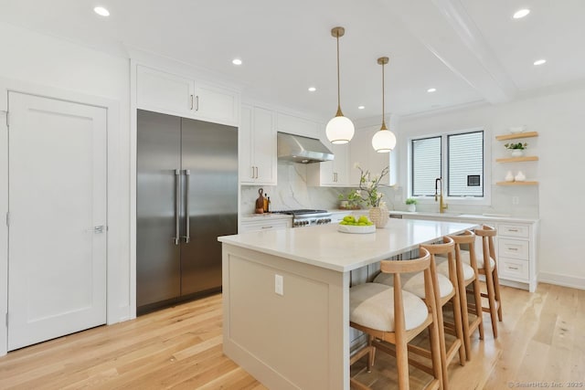 345 Reef Rd Unit B6, Fairfield, CT 06824 - kitchen with stainless steel built in refrigerator, decorative backsplash, a center island, light wood finished floors, and white cabinets