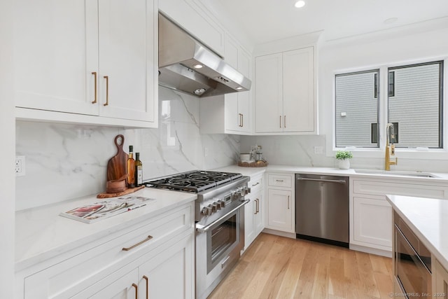 345 Reef Rd Unit B6, Fairfield, CT 06824 - kitchen featuring appliances with stainless steel finishes, range hood, white cabinetry, light countertops, and backsplash