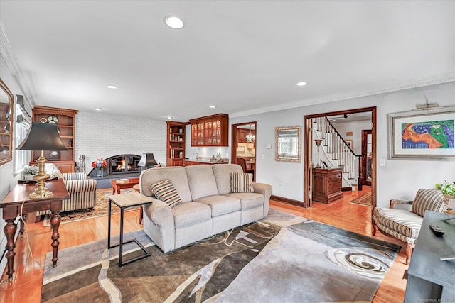70 Cali Dr, Shelton, CT 06484 - living room featuring recessed lighting, stairway, light wood finished floors, ornamental molding, and a fireplace