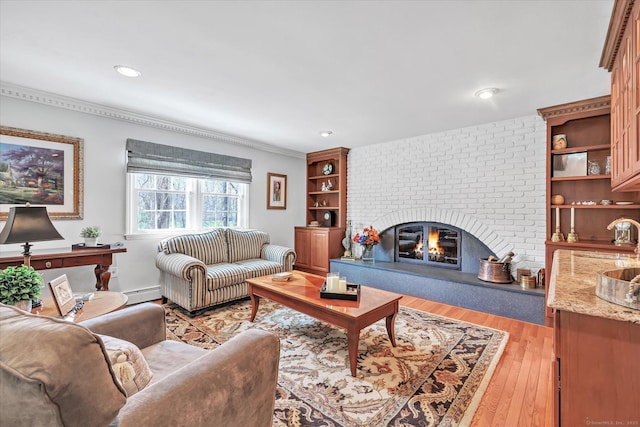 70 Cali Dr, Shelton, CT 06484 - living room with light wood-type flooring, recessed lighting, baseboard heating, a brick fireplace, and ornamental molding
