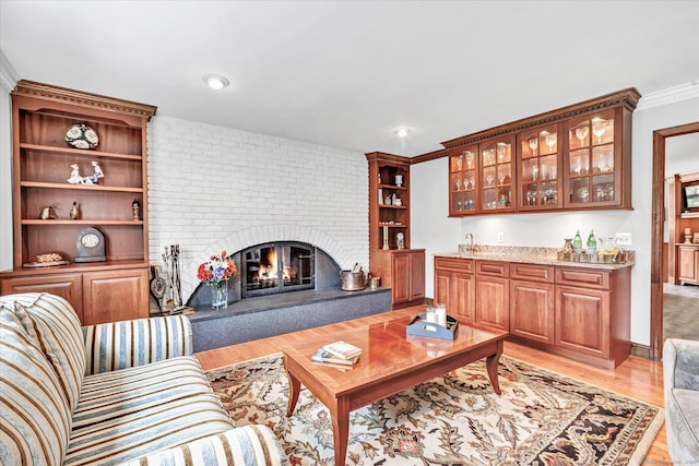 70 Cali Dr, Shelton, CT 06484 - living room with light wood finished floors, indoor wet bar, a brick fireplace, and ornamental molding