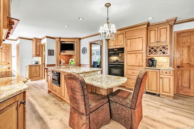 70 Cali Dr, Shelton, CT 06484 - kitchen with light wood-type flooring, a kitchen island, a chandelier, and black appliances
