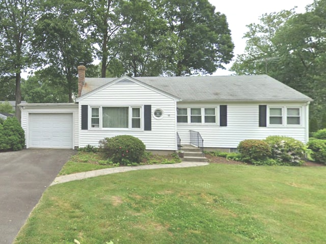 view of front of house with a garage, driveway, and a front yard