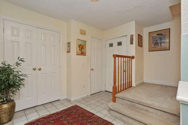 37 Wilton Crst, Wilton, CT 06897 - entrance foyer featuring light tile patterned floors, baseboards, stairway, and a textured ceiling