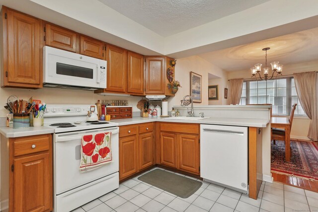 37 Wilton Crst, Wilton, CT 06897 - kitchen featuring white appliances, a sink, a peninsula, a chandelier, and light countertops