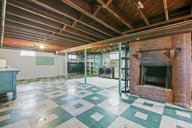 basement featuring separate washer and dryer, tile patterned floors, heating fuel, and a fireplace