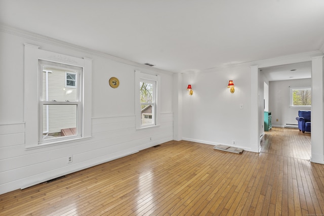 unfurnished living room with wood-type flooring, plenty of natural light, and visible vents