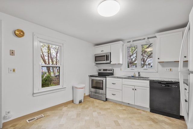 kitchen with a healthy amount of sunlight, appliances with stainless steel finishes, a sink, and visible vents