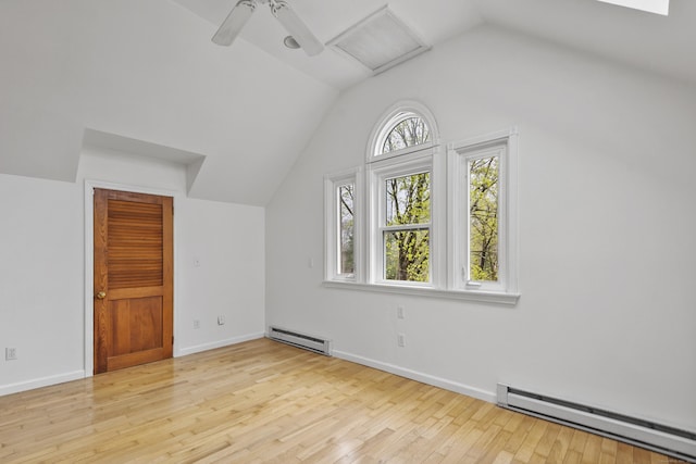 additional living space featuring attic access, a baseboard heating unit, wood finished floors, and vaulted ceiling