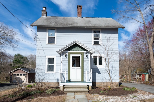 view of front of house featuring a garage and a chimney