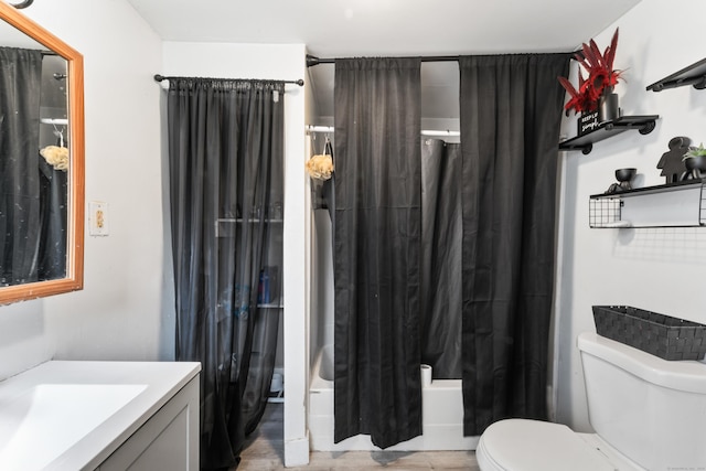bathroom with shower / tub combo with curtain, vanity, toilet, and wood finished floors