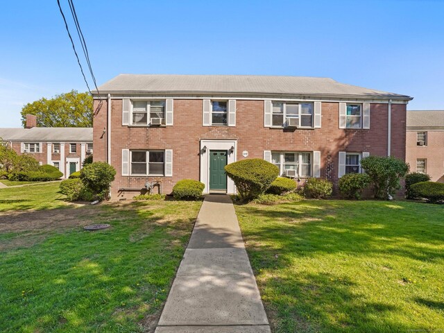 colonial home with brick siding and a front yard