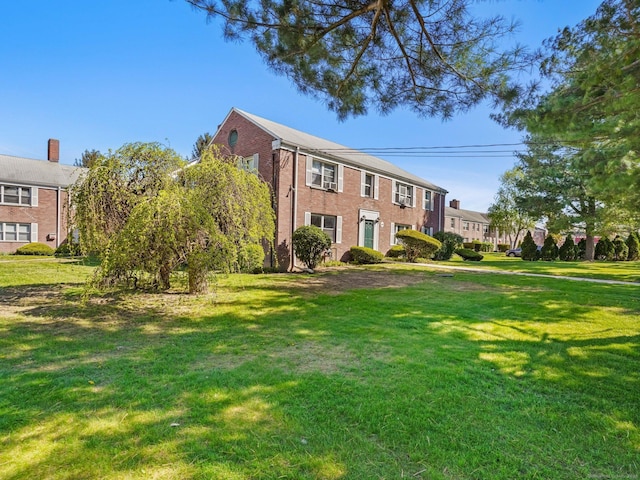 colonial house with brick siding and a front lawn
