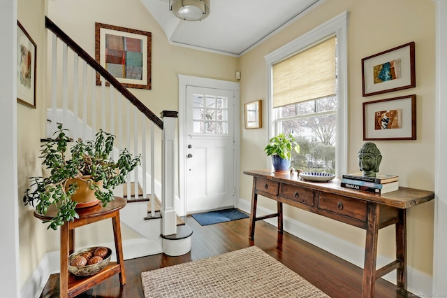 foyer featuring dark wood-type flooring, baseboards, and stairs