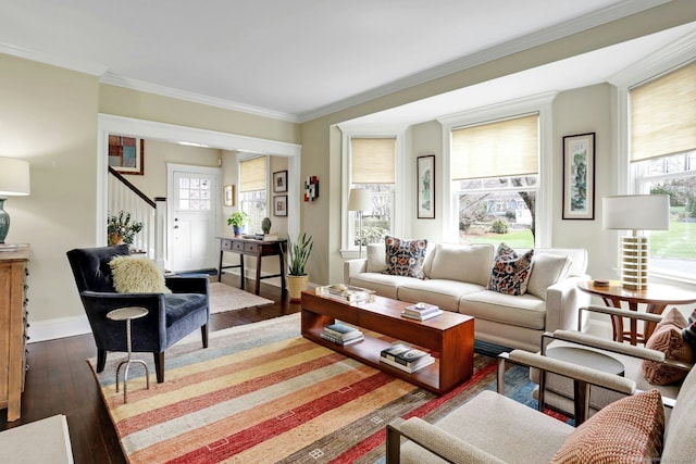 living room featuring baseboards, crown molding, wood finished floors, and stairs