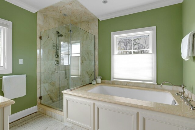 bathroom with a bath, baseboards, ornamental molding, and a stall shower