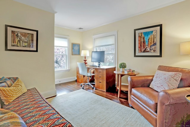home office featuring wood finished floors, visible vents, crown molding, and baseboards