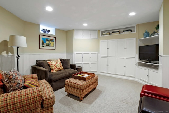 living room with light carpet, a wainscoted wall, and recessed lighting