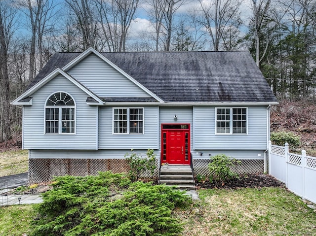 view of front facade featuring fence and a shingled roof