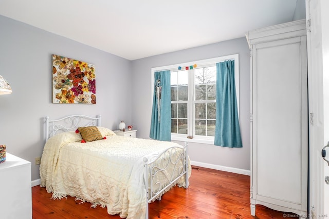bedroom with wood finished floors and baseboards