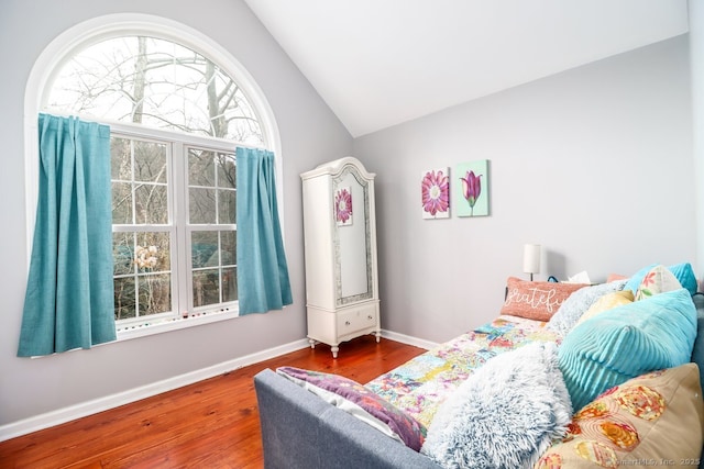 bedroom featuring baseboards, vaulted ceiling, and wood finished floors
