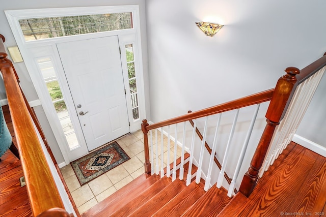 entrance foyer with stairs, baseboards, and tile patterned flooring