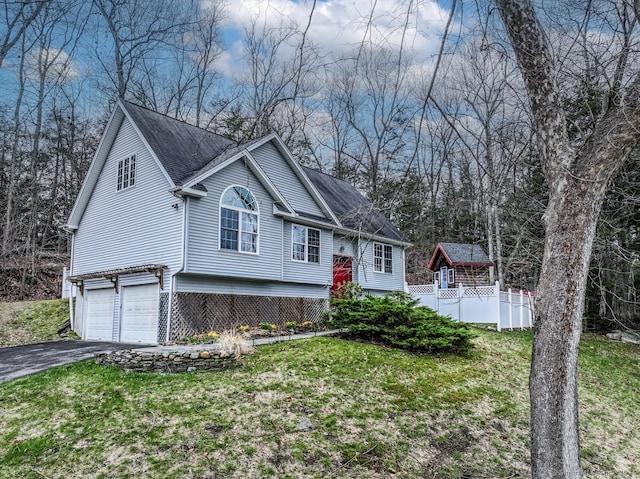view of front of house with a garage, aphalt driveway, a shingled roof, and a front lawn